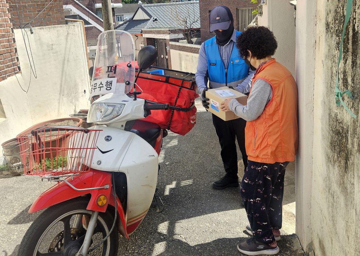 Why does the Andong postman knock on the doors of 180 households every month?