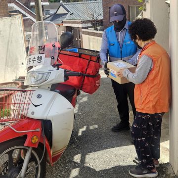 Why does the Andong postman knock on the doors of 180 households every month?