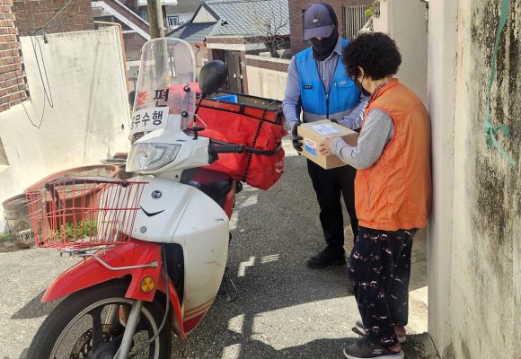 Why does the Andong postman knock on the doors of 180 households every month?